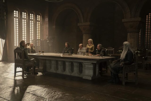 Rhys Ifans (Otto Hightower), Paddy Considine (Viserys Targaryen), Gavin Spokes (Lord Lyonel Strong), David Horovitch (Gran Maestre Mellos), Milly Alcock (Rhaenyra Targaryen), Bill Paterson (Lord Lyman Beesbury) y Steve Toussaint (Lord Corlys Velaryon) en House of the Dragon (La Casa del Dragón) 1x02