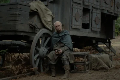 Aegon II Targaryen sentado junto a un carromato con un cuervo cerca - House of the Dragon 3x05 - Temporada 3 Capítulo 5