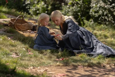 Helaena Targaryen junto a su hija sentadas sobre el césped - House of the Dragon 3x04