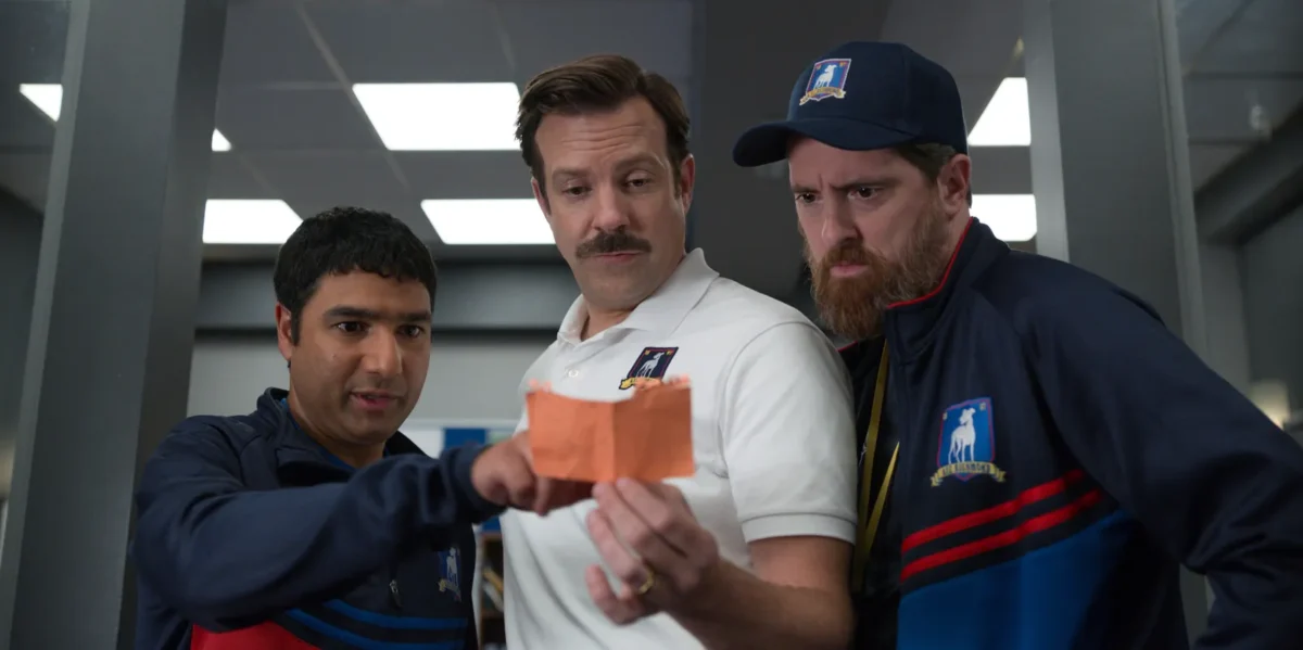 Nick Mohammed como Nate Shelley, Jason Sudeikis como Ted Lasso, y Brendan Hunt como Coach Beard